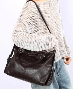 Detail of soft dark coffee leather tote bag with elegant tassel and smooth grain finish