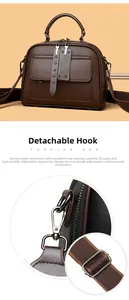 Detail view of dark brown leather crossbody bag with detachable metal hooks and strap