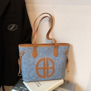 Blue felt tote bag with brown leather trim and AB logo on a minimalist business background
