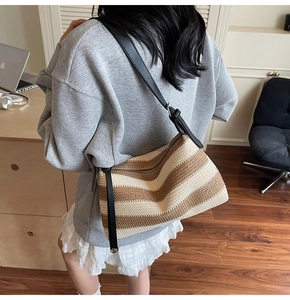 Detail of woven pillow bag with wavy stripes and slim leather strap for casual wear