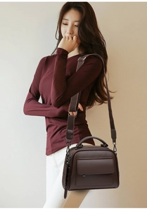 Detailed view of dark brown litchi pattern leather handbag with crossbody strap