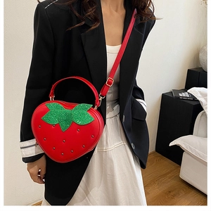 Vue détaillée du sac fraise avec rivets argentés et feuilles vertes à paillettes