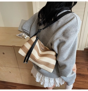 Detail of bohemian striped woven shoulder bag with adjustable black synthetic leather strap