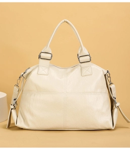 Detail of cream Boston bag with cross-stitch pattern and silver-tone metal hardware