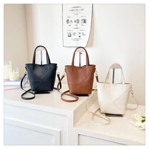 Trois sacs seau avec coutures géométriques en noir, marron et blanc crème