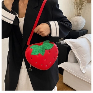Détails du sac fraise rouge avec des feuilles vertes pailletées et des rivets décoratifs