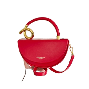 Red half-moon leather handbag with distinctive gold knot metal handle and shoulder strap