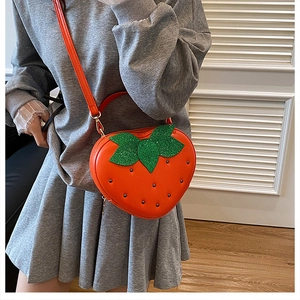 Détail du sac fraise avec clous noirs et feuilles vertes scintillantes à paillettes
