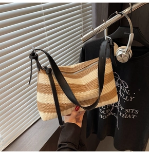 Detailed view of casual striped woven shoulder bag with black leather strap and zipper