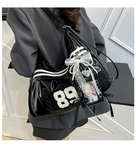 Y2K glossy black tote bag featuring a vintage 89 patch, lace bows, and pearl charms