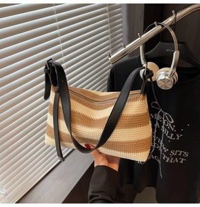 Detail of wave pattern straw woven bag with black leather strap and zipper closure