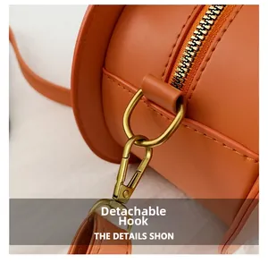Detail of detachable bronze metal hook and zipper on orange pumpkin crossbody bag