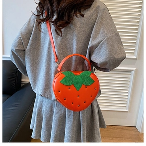Détail du sac fraise avec feuilles scintillantes et rivets métalliques décoratifs