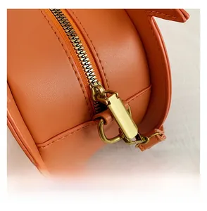 Close-up of smooth orange leather texture with a high-quality metal zipper and stitching