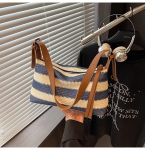 Close-up of woven blue striped bag with adjustable brown leather shoulder strap