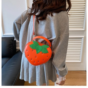 Détail du sac fraise avec feuille en paillettes vertes et rivets argentés brillants