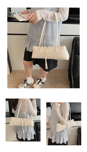 Detailed close-up of cream woven baguette bag featuring intricate cross-knit texture
