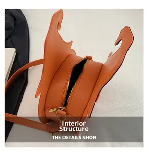 Internal structure of orange bat shaped leather handbag with golden zipper detail