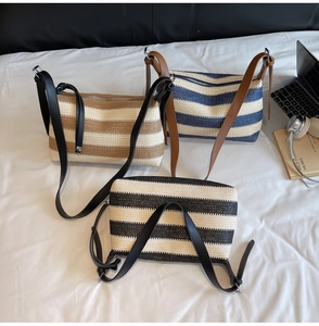 Close-up of striped straw crossbody bag with top zipper and adjustable leather strap