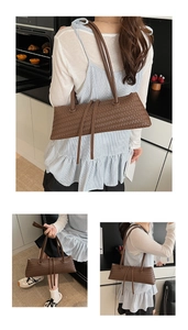 Detail of dark brown woven leather underarm bag with slim handles and long zip puller