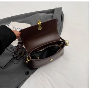 Detail of dark brown vintage flap bag showing inner zipper pocket and gold buckle