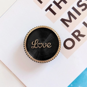 Black round phone grip with golden Love lettering and metallic spiral texture
