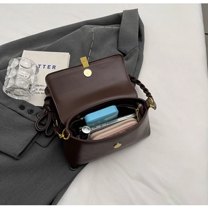 Detail of vintage brown crossbody bag interior showing capacity for wallet and phone