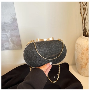 Detail of glitter evening clutch with golden bow clasp and detachable chain strap
