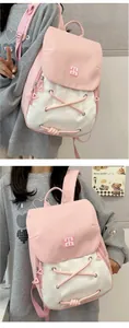 Detail of pink and white canvas backpack featuring decorative criss-cross straps and logo