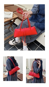 Detail of red woven leather underarm bag featuring dual straps and long decorative tassels