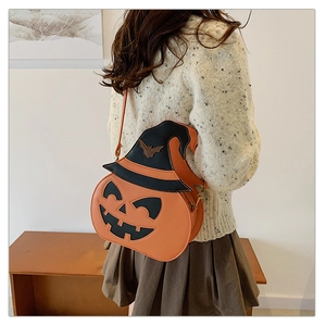 Lifestyle shot of an orange pumpkin crossbody bag with wizard hat and bat detail