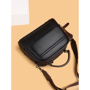 Classic black leather handbag with brown trim and adjustable wide strap for women