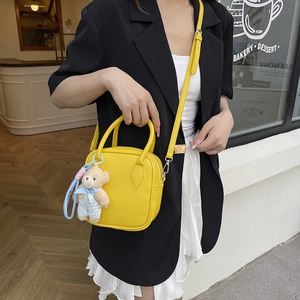 Minimalist yellow pebble leather square crossbody bag with cute teddy bear pendant charm