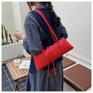 Vue détaillée d'un sac à bandoulière tressé rouge vif avec une texture géométrique