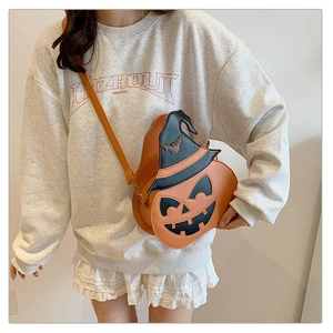 Detail of pumpkin crossbody bag with witch hat design and leather strap on model