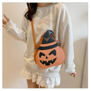 Detail of the orange pumpkin crossbody bag featuring a black wizard hat and smiling face