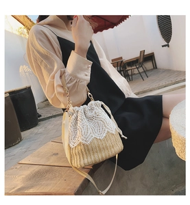 Detailed view of woven straw bucket bag with white lace trim and drawstring closure