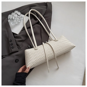 Detail of white woven underarm bag featuring premium faux leather texture and shoulder strap