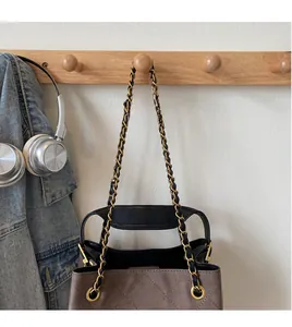 Detail view of the golden chain strap and quilted texture on a brown shoulder bag