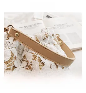 Detail showing the white floral crochet lace pattern and premium leather handle on the bag