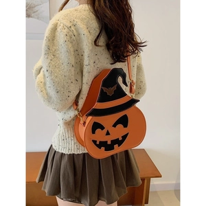 Halloween pumpkin shoulder bag with wizard hat design worn by model in warm interior