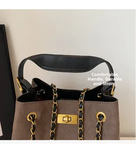 Detail of brown quilted suede bag showing gold twist lock and metal chain strap