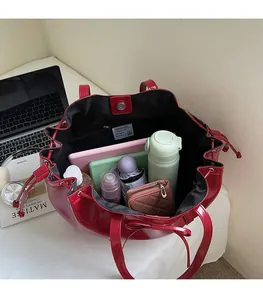 Top view of large red glossy tote bag interior with drawstring and magnetic closure