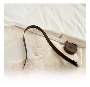 Detailed top view of brown leather bucket bag with slim straps and matte texture