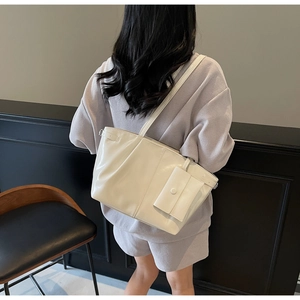 Dettaglio della borsa tote in pelle bianco avorio con borsellino abbinato in stile sobrio