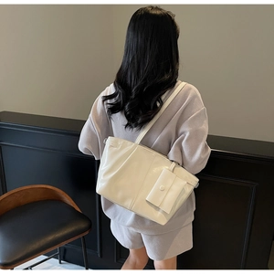 Dettaglio di una borsa tote bianca con borsellino indossata da una modella per il lavoro
