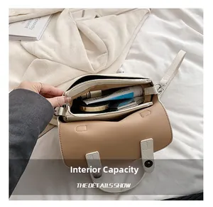 Dettaglio della borsa squadrata beige con doppi scomparti interni e chiusura a zip