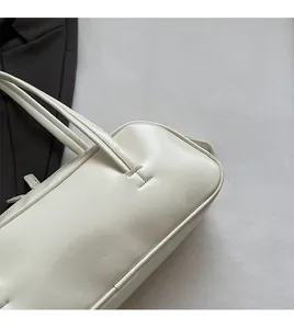 Vue détaillée du sac à main en similicuir beige montrant la texture lisse