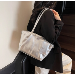 Dettaglio di una grande borsa tote argento con texture metallica e portamonete coordinato