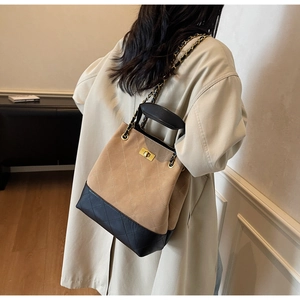 Detail of quilted bucket bag with leather-chain strap and golden twist lock closure